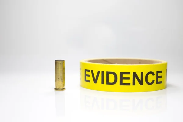 Nastro di prova con cassa proiettile in ottone su sfondo bianco — Foto Stock