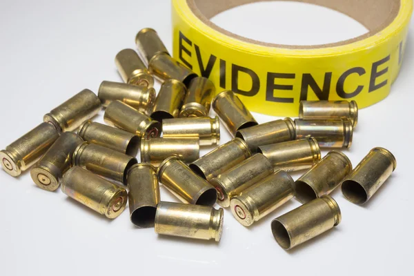 evidence tape with brass bullet cases on white background