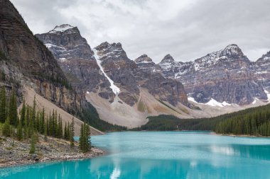 Yaz sabahı Moraine Gölü, Alberta Kanada 'da, Tayga ormanı ve kayalık dağlarla çevrili güzel bir turkuaz su.