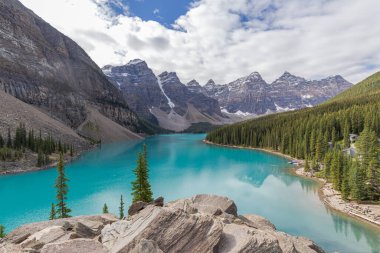 Yaz sabahı Moraine Gölü, Alberta Kanada 'da, Tayga ormanı ve kayalık dağlarla çevrili güzel bir turkuaz su.