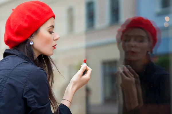 Egy lány a red svájcisapka sétál körül város komor Időjárás Stock Fotó