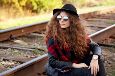 sonbahar güneşli havalarda raylar üzerinde bir kız oturuyor