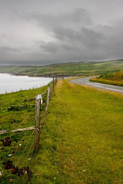 Забор и дорога на острове Скай, Шотландия — стоковое фото