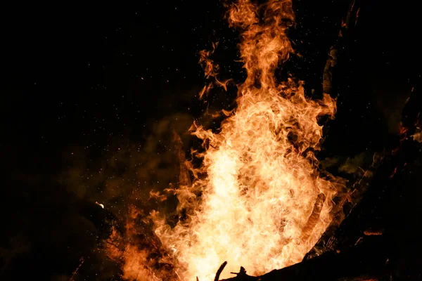 美しい火花と黒の背景と地面に赤い炎の薪で火災 — ストック写真