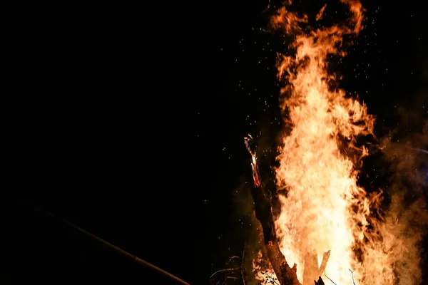 美しい火花と黒の背景と地面に赤い炎の薪で火災 — ストック写真