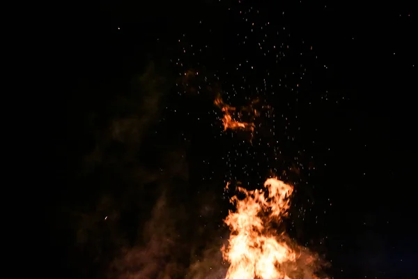 在地上燃着柴火 红色的火焰 黑色的背景和美丽的火花 — 图库照片