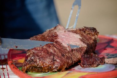 Masanın üzerinde orta pişmiş Picanha dilimi..