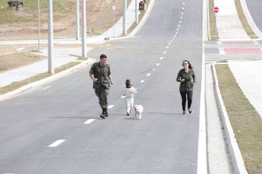 Beyaz elbiseli ve güneş gözlüklü güzel çocuk Golden Retriever köpeğiyle oynuyor. .