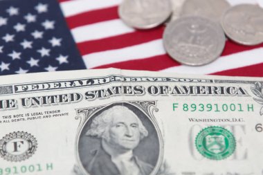 Altında bozuk para ve bayrak olan 1 dolarlık ABD banknotu..