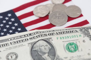 Altında bozuk para ve bayrak olan 1 dolarlık ABD banknotu..