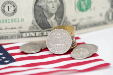 Altında bozuk para ve bayrak olan 1 dolarlık ABD banknotu..