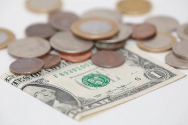 Altında bozuk para ve bayrak olan 1 dolarlık ABD banknotu..