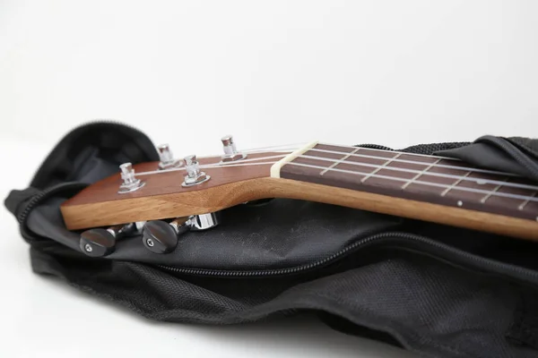 黑色封面上的小棕色木制四边形吉他 — 图库照片