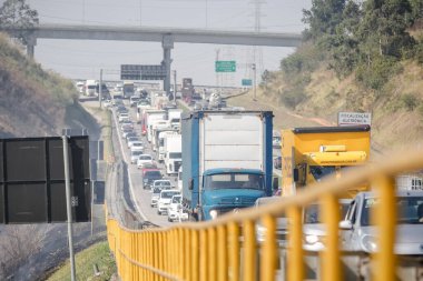 Dutra otoyolunun yanındaki yangın trafiği yavaşlatıyor, itfaiyeciler yangını söndürüyor..