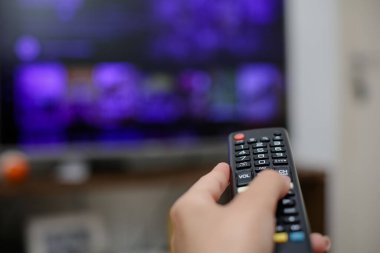 TV uzaktan kumandası açılacak ve dizileri ve filmleri izleyecek.