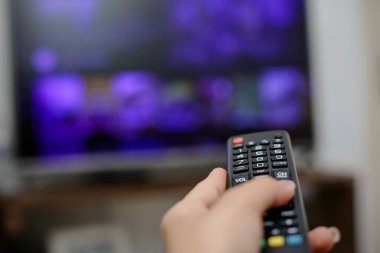 TV uzaktan kumandası açılacak ve dizileri ve filmleri izleyecek.