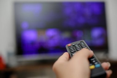 TV uzaktan kumandası açılacak ve dizileri ve filmleri izleyecek.