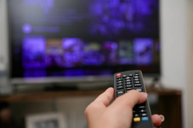 TV uzaktan kumandası açılacak ve dizileri ve filmleri izleyecek.