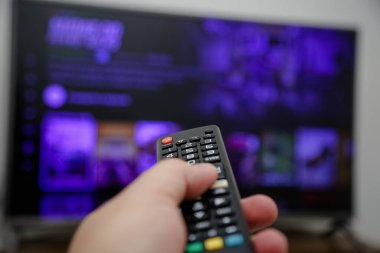 TV uzaktan kumandası açılacak ve dizileri ve filmleri izleyecek.