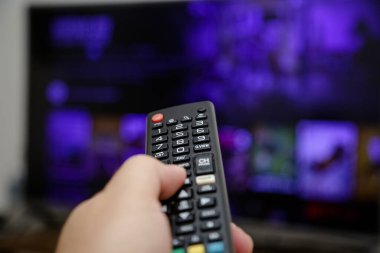 TV uzaktan kumandası açılacak ve dizileri ve filmleri izleyecek.