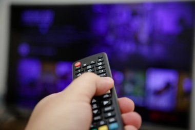 TV uzaktan kumandası açılacak ve dizileri ve filmleri izleyecek.