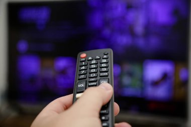 TV uzaktan kumandası açılacak ve dizileri ve filmleri izleyecek.