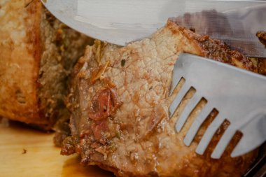 Tahtada bıçak ve çatal bıçakla pişirilmiş et dilimi..