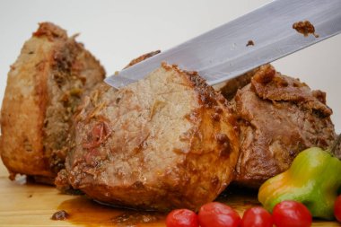 Tahtada bıçak ve çatal bıçakla pişirilmiş et dilimi..