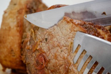 Tahtada bıçak ve çatal bıçakla pişirilmiş et dilimi..