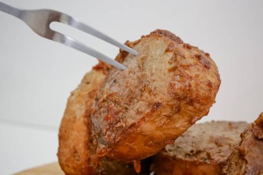 Tahtada bıçak ve çatal bıçakla pişirilmiş et dilimi..