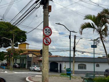 Sarı oklu trafik levhası ve vahşi doğanın bulanık arka planına sahip bir direkte sabit hız kameraları..