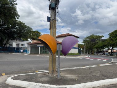 Sarı oklu trafik levhası ve vahşi doğanın bulanık arka planına sahip bir direkte sabit hız kameraları..