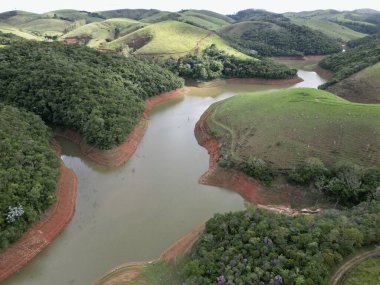 Düşük su hacmi ve çevresindeki manzaralarla bir su krizi yaşayan bir barajın yukarıdan görüntüsü.