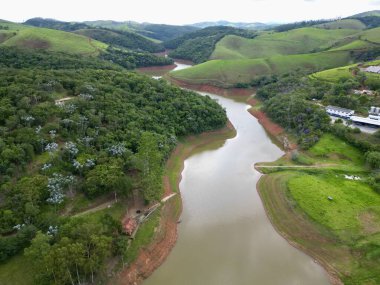 Düşük su hacmi ve çevresindeki manzaralarla bir su krizi yaşayan bir barajın yukarıdan görüntüsü.