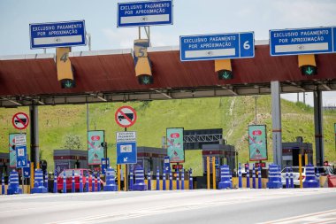 Hareketliliği, ulaşımı, lojistiği ve şehirler arasındaki bağlantıyı sembolize eden işlek bir otoyoldaki gişe. Trafik kavramı, modern altyapı, seyahat, seyahat ve ekonomik akış.