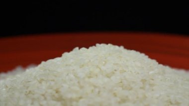 Bir kırmızı plaka dönen üzerinde avuç pirinç