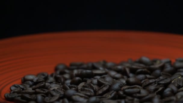 Granos de café girando en una placa roja — Vídeos de Stock