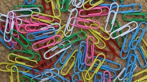 Colorful Paper Clip Clasp Office Stuff Rotating on a Cork Table Clerical Footage — Stock Video