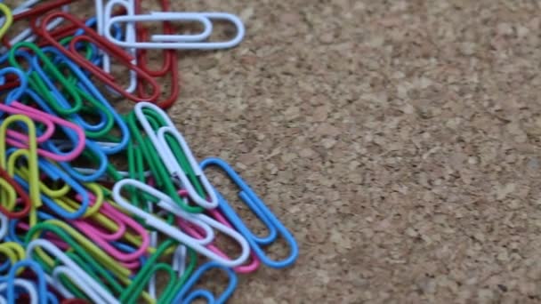 Colorful Paper Clip Clasp Office Stuff Slide on a Cork Table Clerical Footage — Stock Video