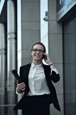 Acele bir toplantı ve smartphone üzerinde konuşmak için ofisine duvarlar boyunca iş kadını gider.