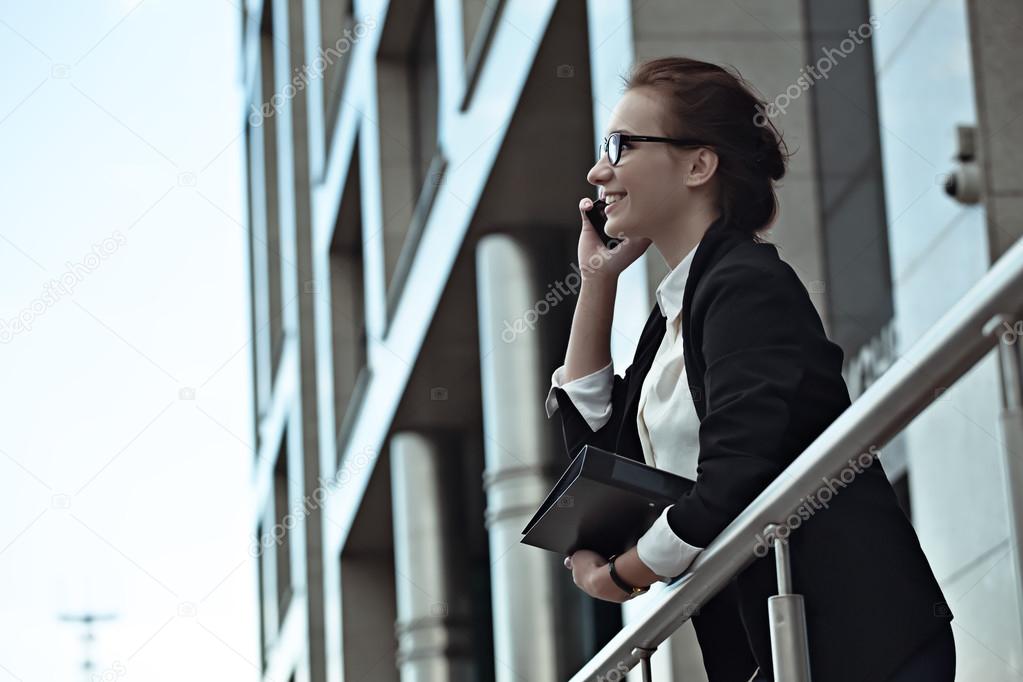 Attractive success business woman smiling and talking on smartphone.