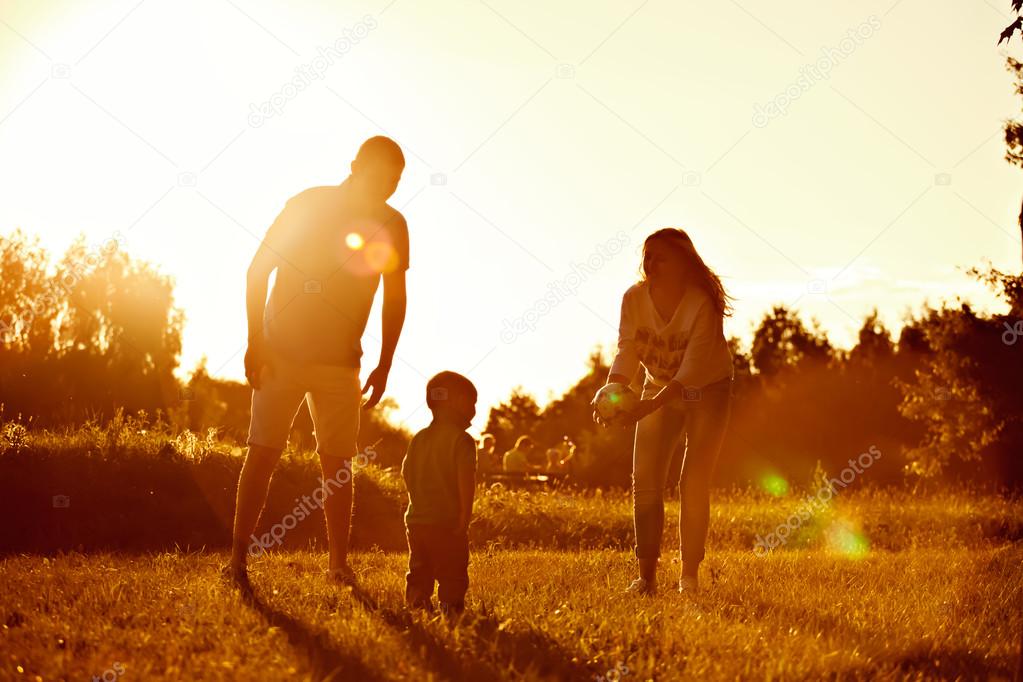Happy family, father, mother, son and in nature, sunset.