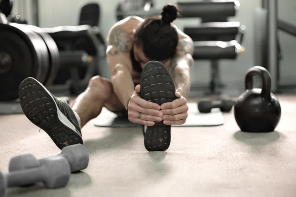 М'язистий чоловік у спортзалі виконує вправи . — стокове фото