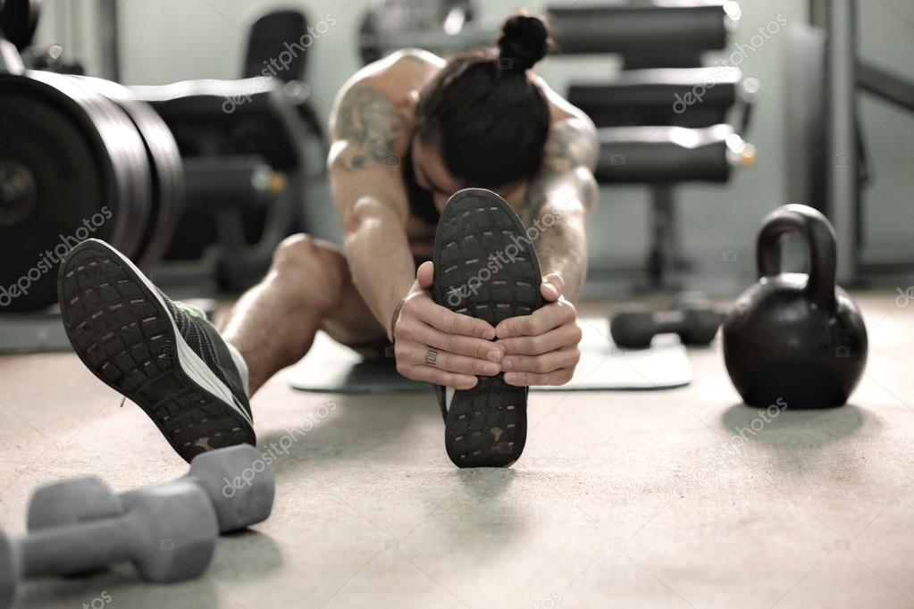 Muscular man in gym doing exercises.