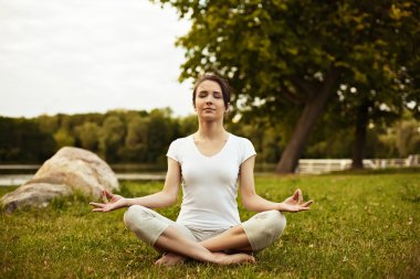 Dinlenirken ve meditasyon - banka nehir kıyısında günbatımı üzerinde meditasyon Yoga kadın.