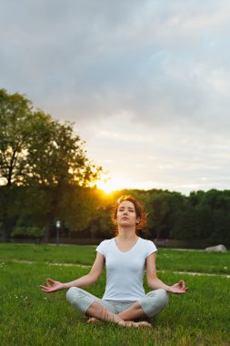 Genç güzel yoga-kız gündoğumu veya günbatımı Park.