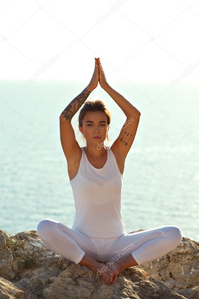 Young asian yoga girl on blue sea background.