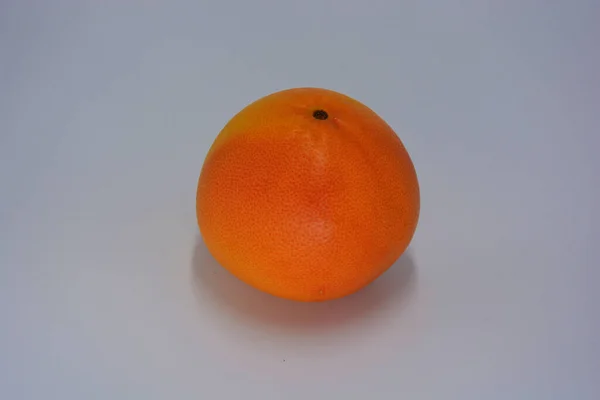 Uma Grande Toranja Vermelha Alaranjada Madura Deliciosa Disposta Prato Branco — Fotografia de Stock