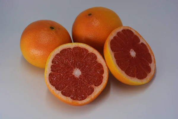 大型成熟的橙黄色柚子 有多汁柚子切割成两部分 位于白色的背景上 美味健康的糖醋水果对人体健康的危害 — 图库照片