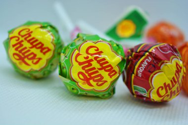 Bir avuç parlak, renkli, popüler emme şekeri. Beyaz plastik çubuklu yuvarlak şekerler..
